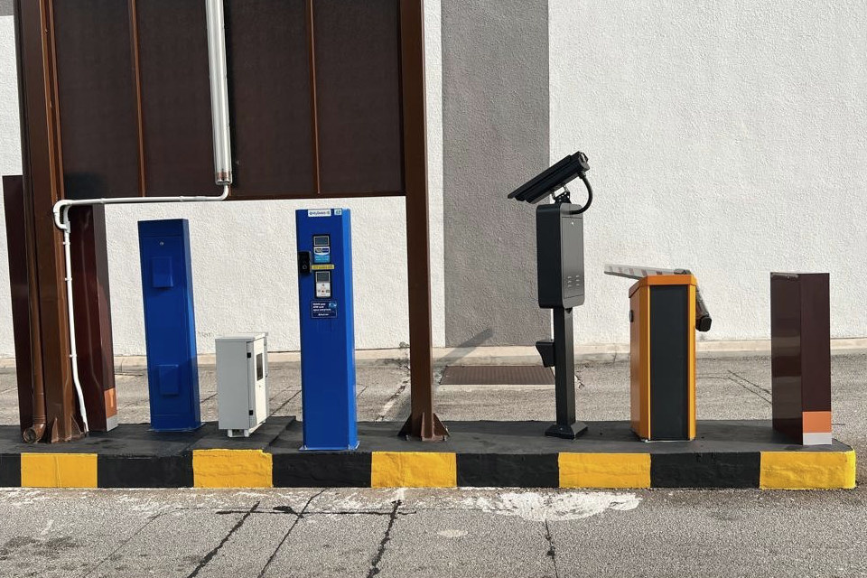 Licence plate recognition camera, payment terminals and barrier installed at a car park lane