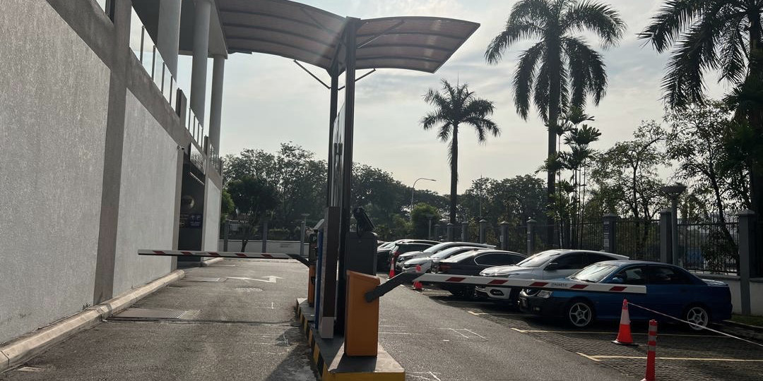 Covered entry lane with a raised barrier arm at a car park under management